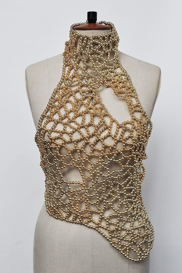 A gold beaded crochet halter top displayed on a beige fabric mannequin torso against a plain white background.