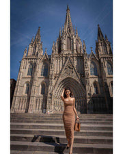 Moni Dress in a beige ruched sleeveless style, fitted through the body with a long skirt and gathered detailing