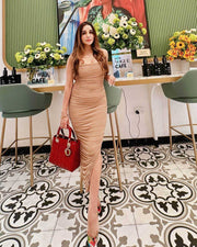 Moni Dress in beige with a sleeveless, fitted silhouette, gathered ruching throughout and a floor-length hem