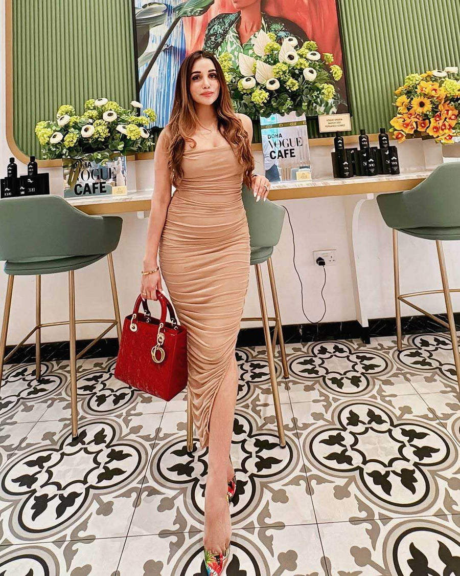 Moni Dress in beige with a sleeveless, fitted silhouette, gathered ruching throughout and a floor-length hem