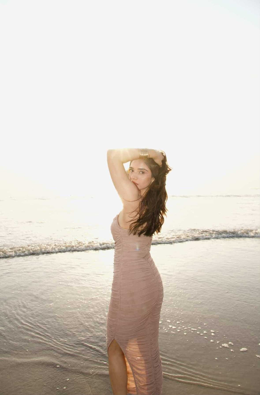 Moni Dress in dusty beige with a fitted sleeveless silhouette, ruched fabric, and a high side slit
