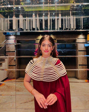 Pearl Cape Top in layered white pearl strands draped over the shoulders, styled with a red outfit