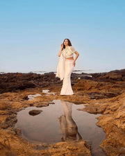 Pearl Cape Top in white with a draped cape sleeve and matching skirt, styled with delicate pearl detailing