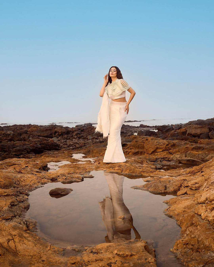 Pearl Cape Top in white with a draped cape sleeve and matching skirt, styled with delicate pearl detailing
