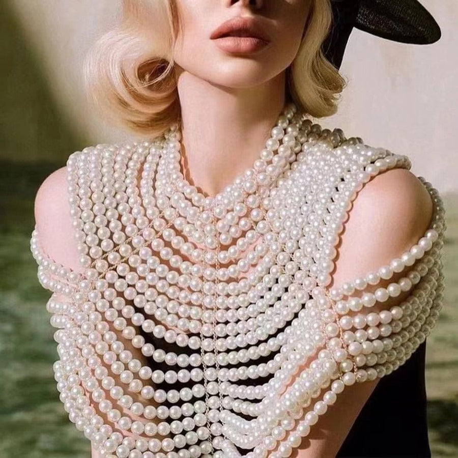 Pearl Cape Top in white pearl strands, with layered draping and open shoulders forming an elegant statement design