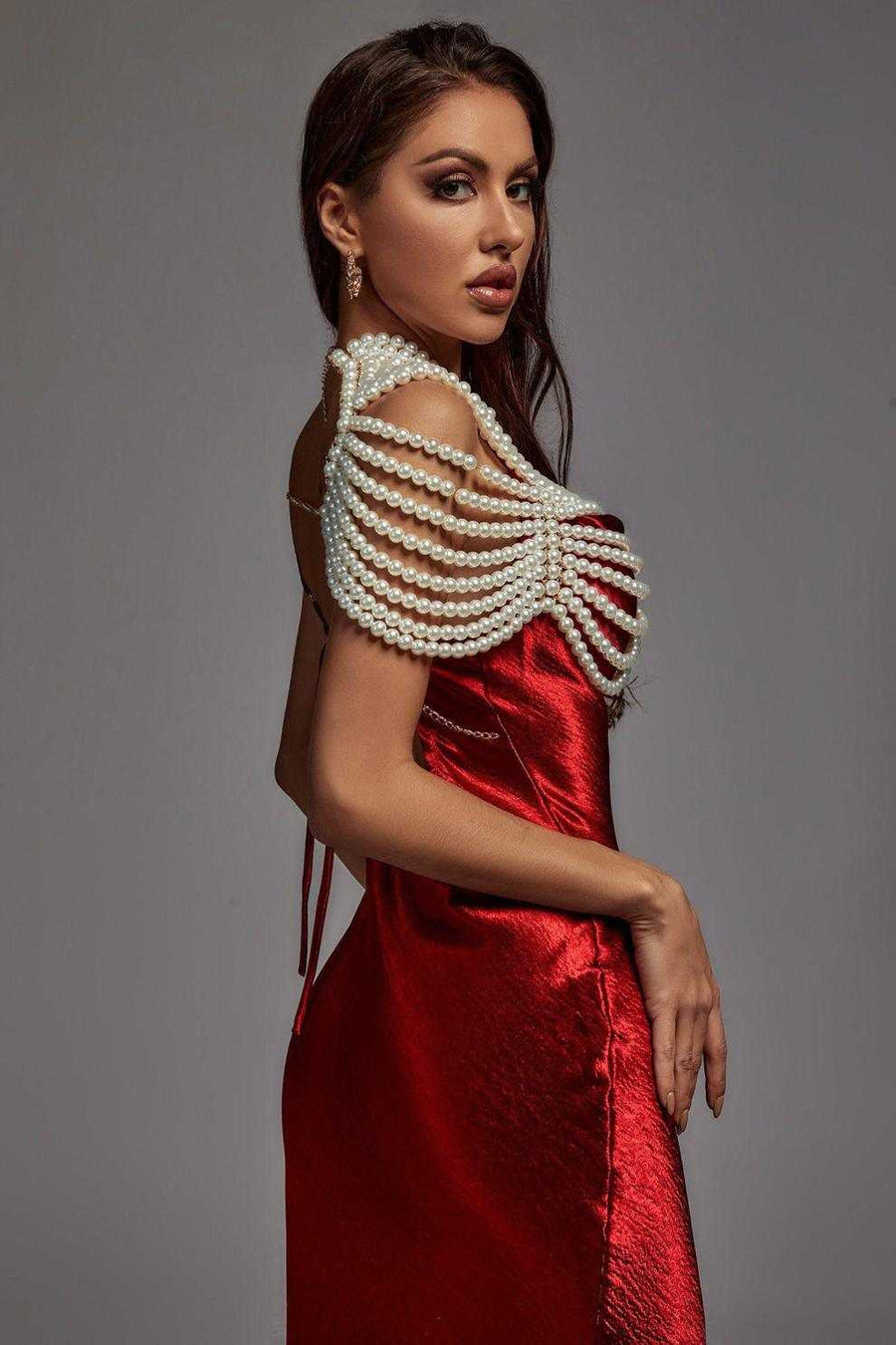 Pearl Cape Top featuring layered white pearl strands draped over the shoulders above a red satin dress