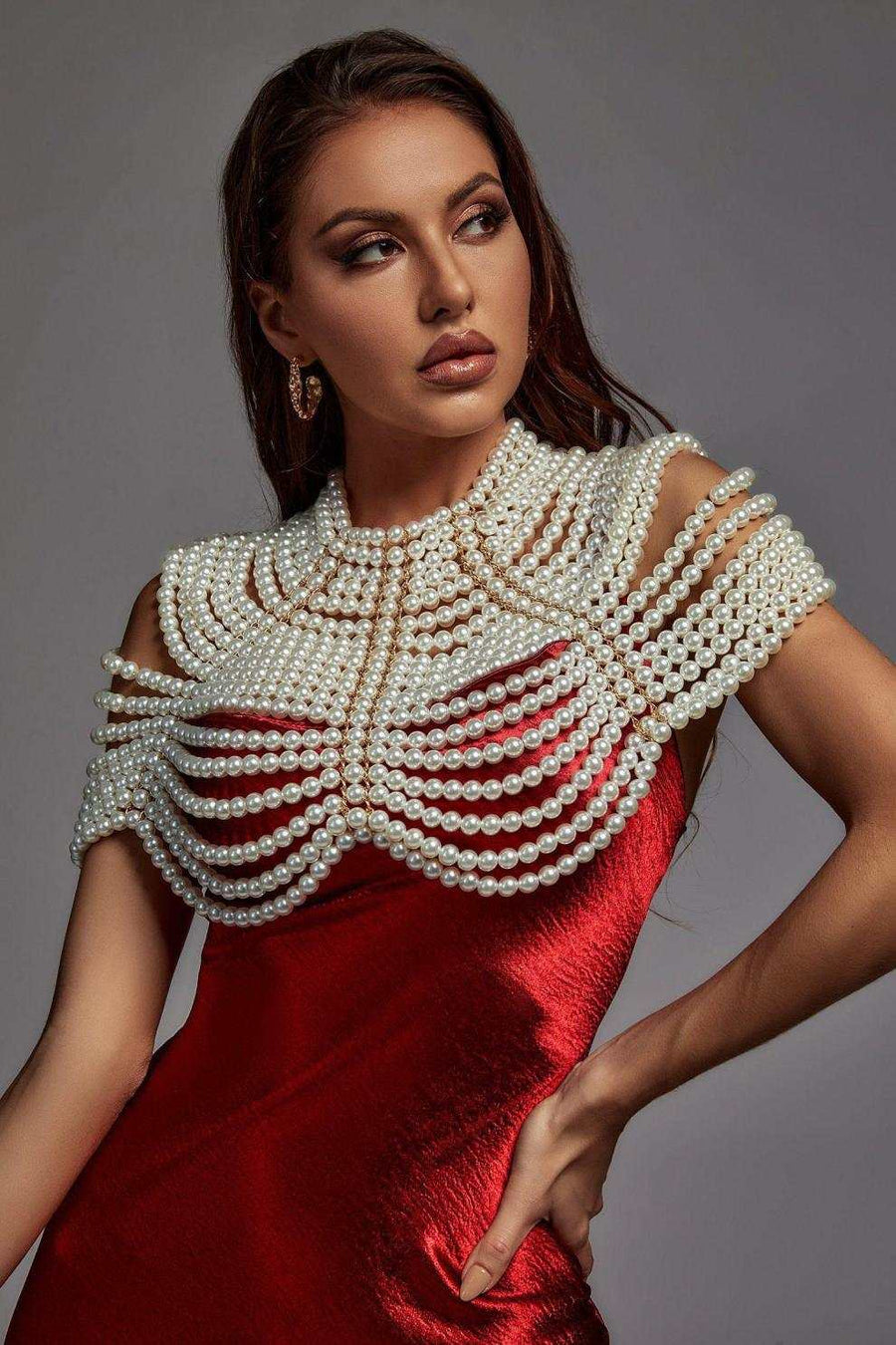 Pearl Cape Top with layered white pearl strands draped over a red satin sleeveless dress