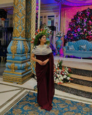 Pearl Cape Top in white pearl strands drapes over a deep burgundy outfit, forming a layered collar and capelet.